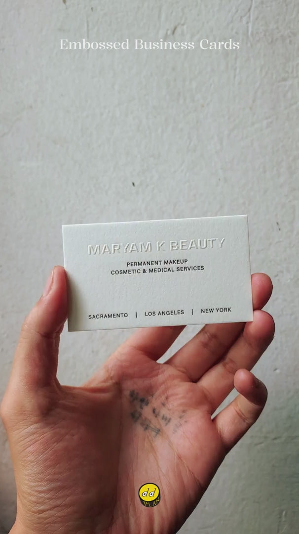 45pt cotton business card with raised embossing on one side and glossy black foil on both sides, showing height and shine.